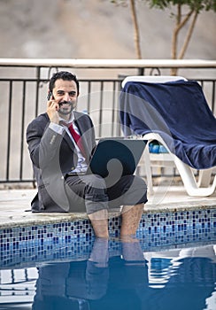 Middle aged arab man by a pool in his business suit