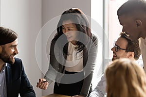 Middle aged Asian businesswoman talking to diverse colleagues at meeting photo