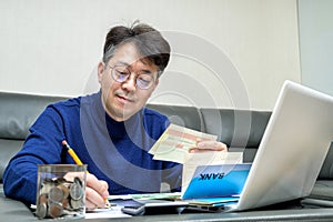 Middle-aged Asian man preparing for tax return