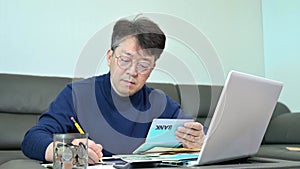 Middle-aged Asian man preparing for tax return.