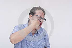 A middle aged asian man punching himself in the face, inflicting self-harm. Isolated on a white backdrop
