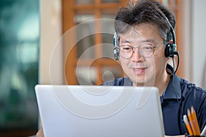 Middle-aged Asian man working at home. Telecommuting concept