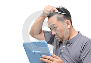 Middle-aged asian man worry about his  hair loss or alopecia and grey hair isolated