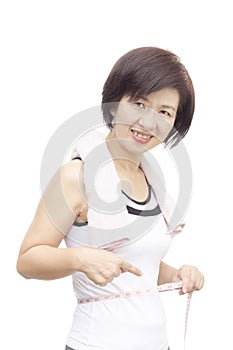 Middle aged asian woman measuring her waist