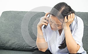 Middle-aged Asian woman is talking on the phone with