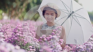 Middle aged asian woman using a tablet while checking the quality of flowers in garden