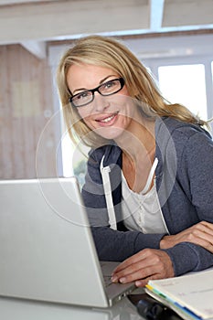 Middle-aged blond woman on laptop