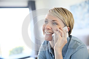 Middle-aged blond woman talking on the phone