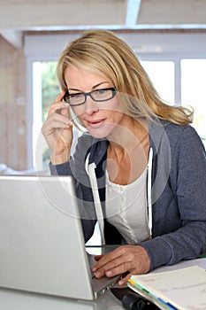 Middle-aged blond woman working on laptop