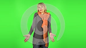 Middle aged blonde woman is saying oh my god and being shocked. Green screen