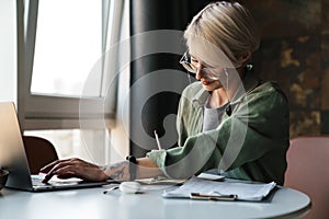 Middle aged blonde woman with short hair studying