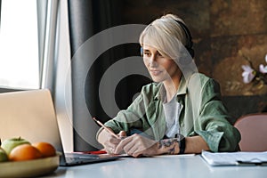 Middle aged blonde woman with short hair studying