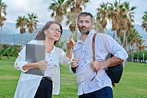 Middle aged business colleagues talking in the park