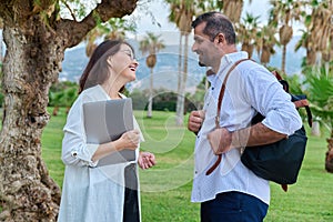 Middle aged business colleagues talking in the park