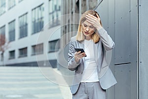 Middle aged business woman, patient has severe headache, businesswoman trying to call doctor using phone