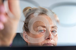 Middle-aged business woman portrait at work behind the computer monitor