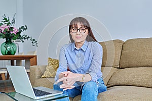 Middle aged business woman working at desk in home office, using laptop