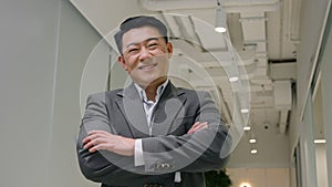 Middle-aged businessman Asian adult man executive manager CEO business company pose with crossed arms smiling glad