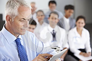 Middle Aged Businessman Delivering Presentation At Conference