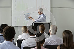 Middle Aged Businessman Delivering Presentation At Conference