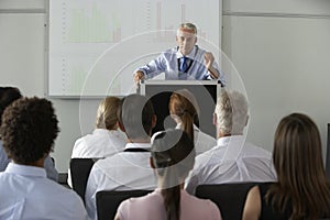 Middle Aged Businessman Delivering Presentation At Conference