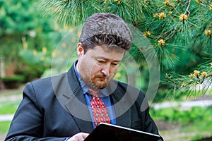 A middle aged businessman holding touchpad