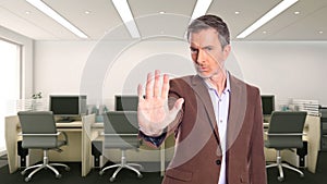 Middle Aged Businessman in an Office with Stop Gesture