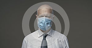 Middle-aged businessman posing with a surgical mask