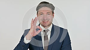 Middle Aged Businessman showing Ok Sign with Finger, White Background