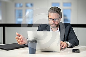 Middle aged businessman working with laptop in office. Hispanic business man using laptop. Millennial man using laptop