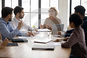 Middle-aged businesswoman lead meeting with employees in office