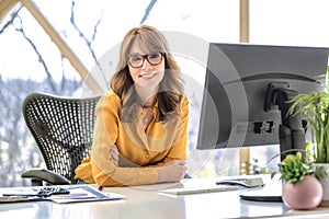 Middle aged businesswoman sitting behind her computer while working from home