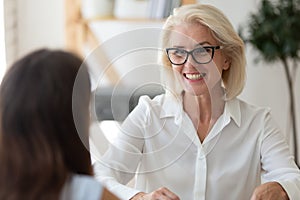 Middle-aged businesswoman talk with business client at office meeting