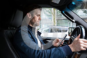 A middle aged caucasian man distracted driving while using a mobile device. photo