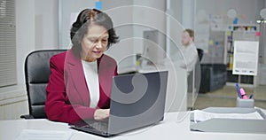 Middle-aged caucasian woman working on laptop computer