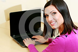 Middle-aged cheerful woman using laptop