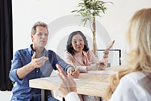 Middle aged colleagues disputing at business meeting