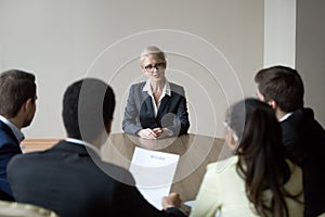 Middle-aged confident applicant talking to hr managers during job interview photo