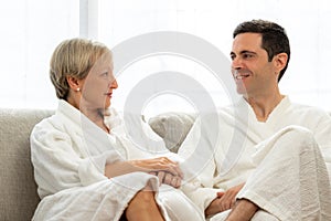Middle aged couple in bathrobes at home.
