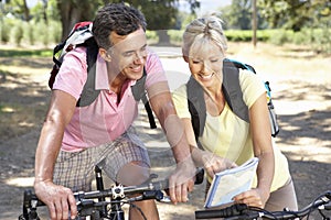 Middle Aged Couple Cycling Through Countryside