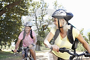 Middle Aged Couple Cycling Through Countryside