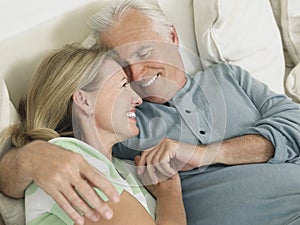 Middle Aged Couple Embracing In Bed