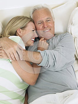 Middle Aged Couple Embracing In Bed