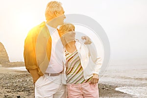 Middle aged couple enjoying the beach with lens flare