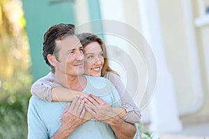 Middle-aged couple in front of the house