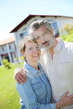 Middle-aged couple in front of their new home