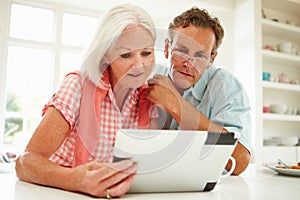 Middle Aged Couple Looking At Digital Tablet