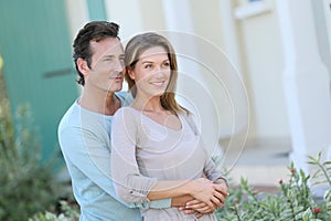 Middle-aged couple looking in front of their home