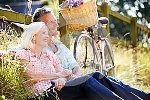 Middle Aged Couple Relaxing On Country Cycle Ride