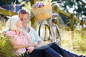 Middle Aged Couple Relaxing On Country Cycle Ride